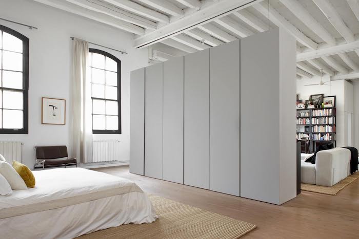 linge de lit blanc, tapis beige, armoire industrielle blanches, grandes fenêtres industrielles, parquet bois clair