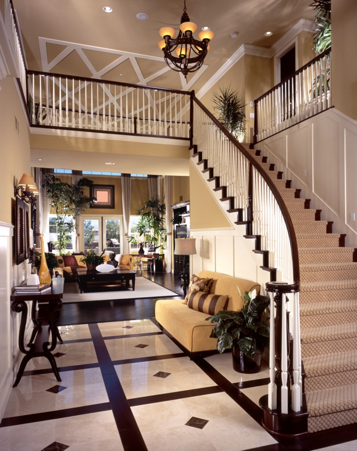 créer une décoration d'entrée chic dans une maison de luxe, grand escalier, console en bois, carrelage en noir et blanc, sofa beige, créer une entrée dans un espace ouvert