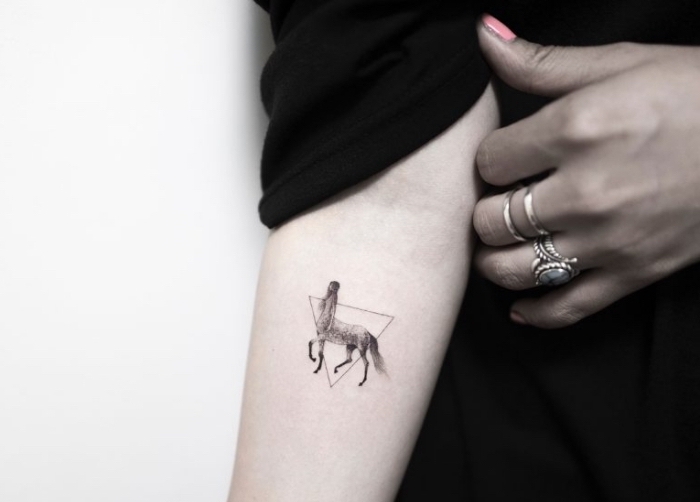 exemple de tattoo à design original avec petit dessin de centaure femme encadré dans un triangle minimaliste