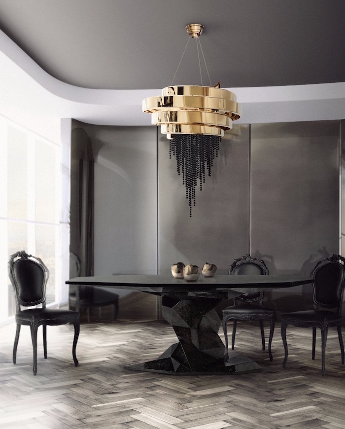 Salle à manger luxe style art moderne avec table noire design et lustre or dans décoration gris anthracite