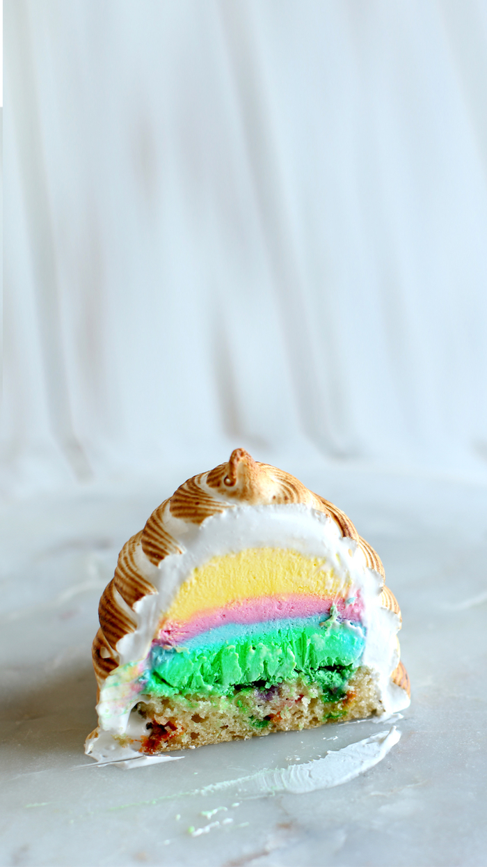 recette de gateau cake façon bombe alaska flambée qui révèles les couleurs de l'arc-en-ciel une fois découpée
