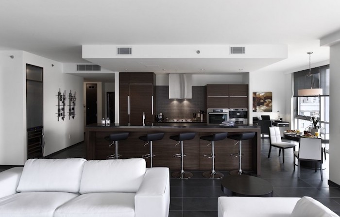 Moderne cuisine avec bar plot cuisine qui donne au salon avec coin salle à manger ultra moderne en blanc et brune 