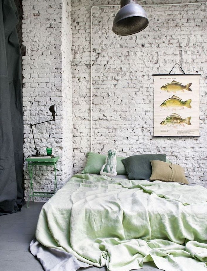 exemple de déco mur de briques blanc, linge de lit vert, sol parquet peinture grise, suspension grise originale