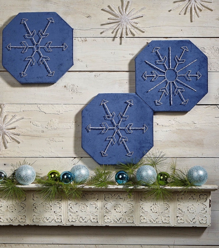activité manuelle maternelle pour faire une décoration de Noel murale, tableau peint en bleu foncé avec flocon de neige en fil blanc