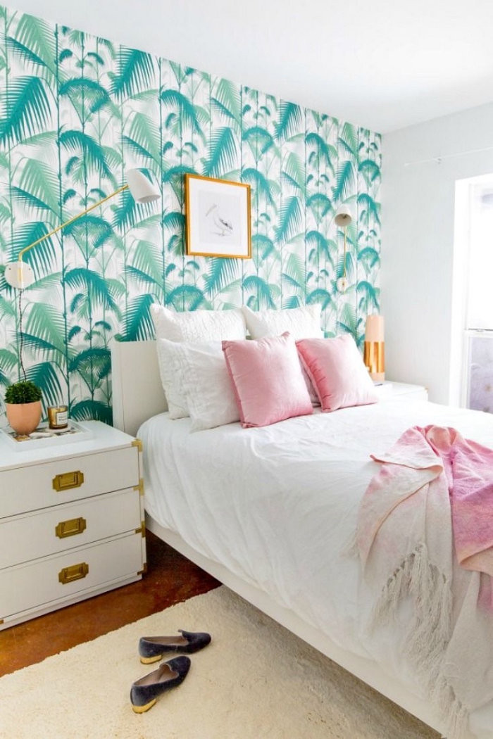 une chambre à coucher élégante et douce avec un espace lit délimité pair la tête de lit en papier peint à motif feuille de palmier