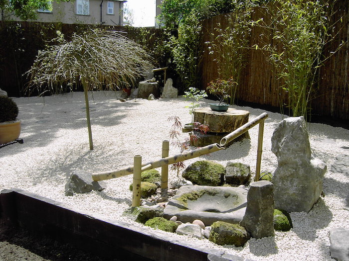 jardin Karesansui japonais avec sol en graviers et fontaine en bambou Kakei