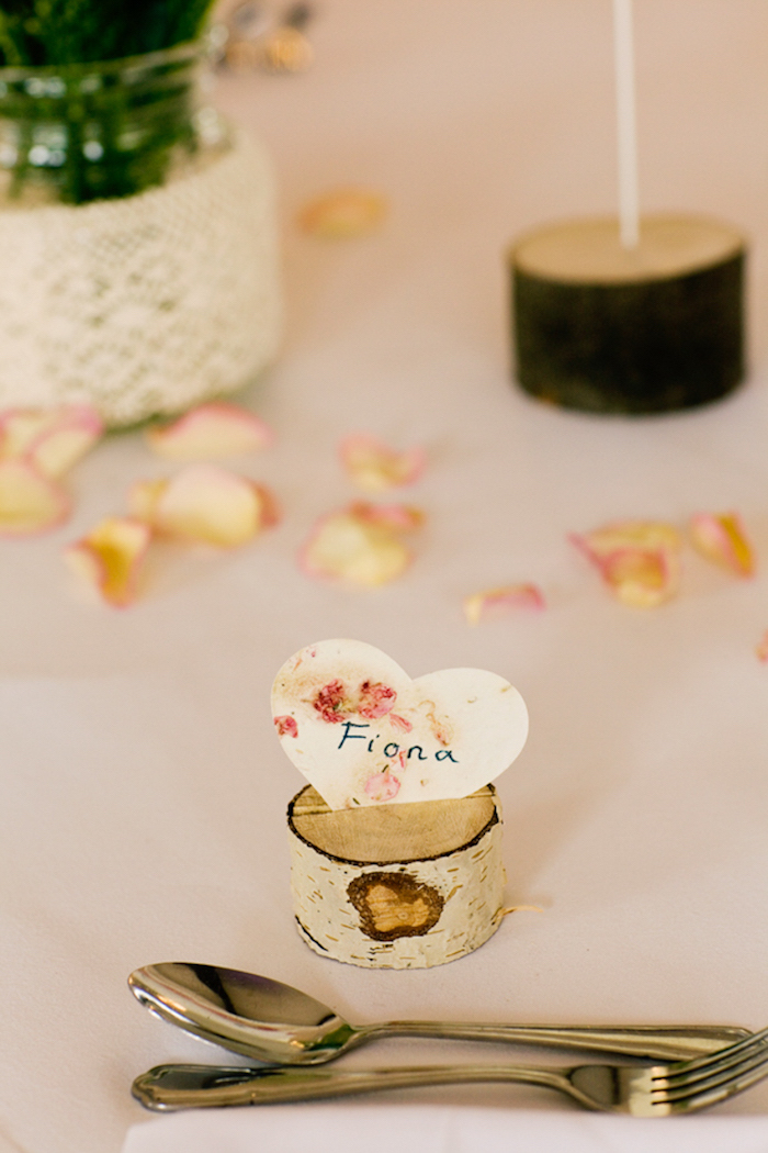 petite rondelle de bois avec une incise et coeur en papier prénom mariage, pétales de fleurs, centre de table floral