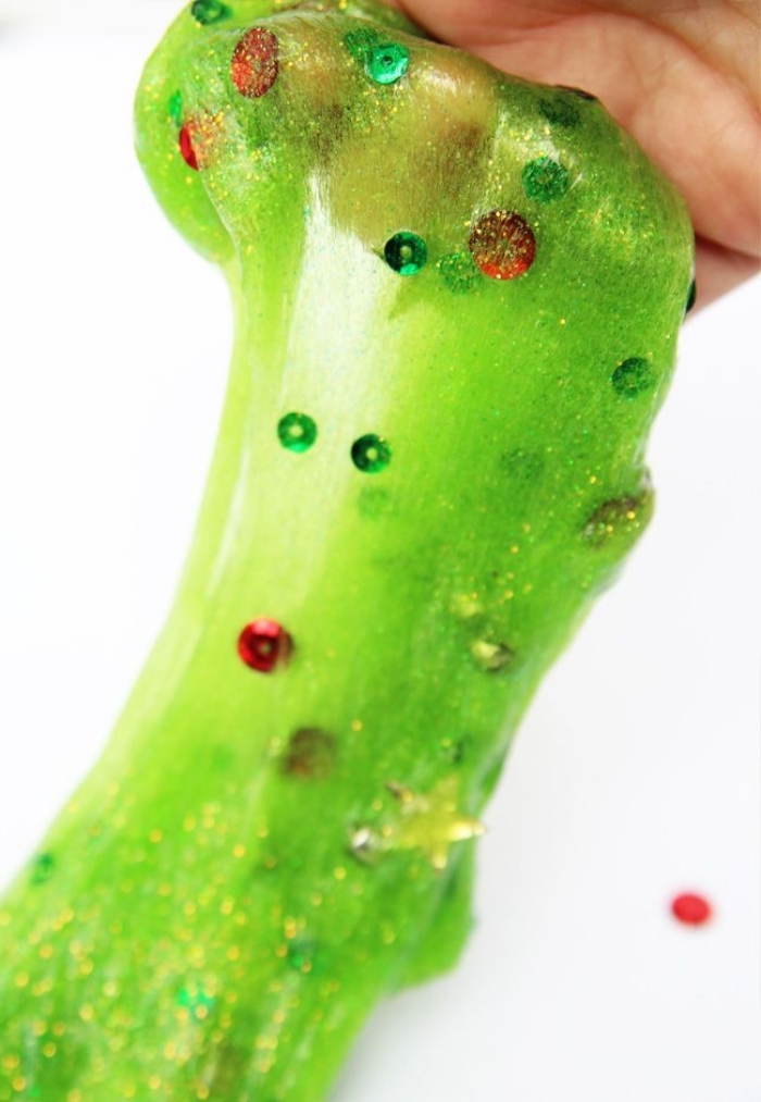 recette du slime de noël vert fluo auquel on a incorporé des paillettes, idée de bricolage de noël amusant pour occuper les enfants 