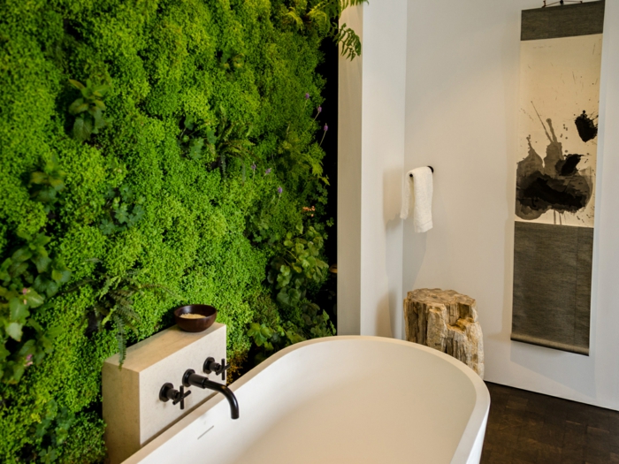 plante salle de bain sans lumière, mur avec végétation mousse verte, plante grimpante interieur, murs blancs, tronc d'arbre comme objet déco dans un angle 