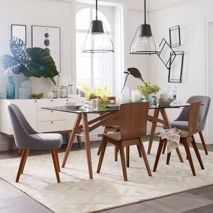 chaises et table à manger scandinave en verre et bois design et éclairage suspendu et murs blancs