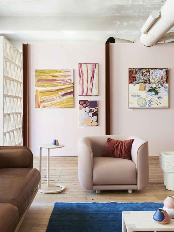 décoration intérieure salon féminine, peintures artistiques, fauteuil gris, petite table blanche, fauteuil marron, sol en bois blanc