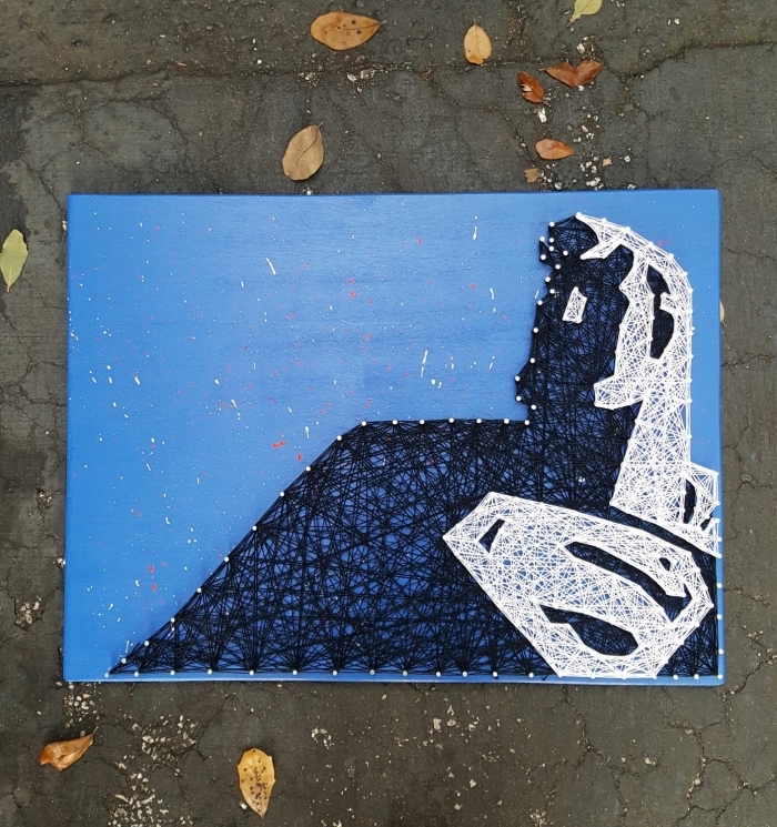 utiliser un gabarit fil tendu pour créer un tableau décoratif peint en bleu avec silhouette d'inspiration superman