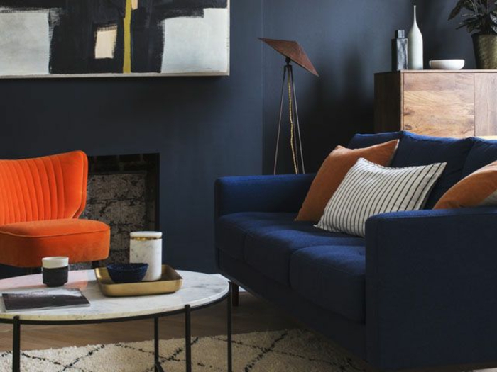 aménagement salon moderne, table basse ovale, tapis berbère, fauteuil orange, canapé bleu deux places, décoration intérieure salon
