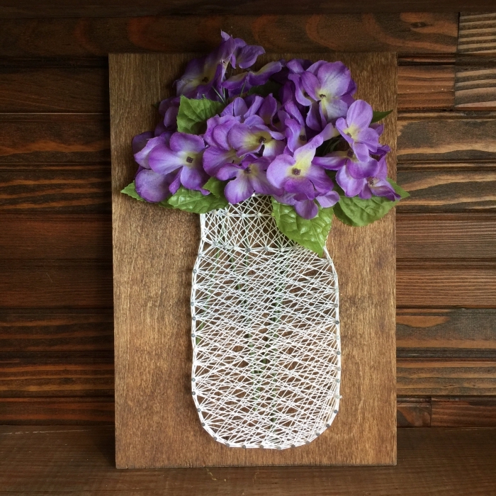 modèle de bricolage facile avec planche de bois foncé et une création en fil blanc en forme de vase avec fleurs artificielles