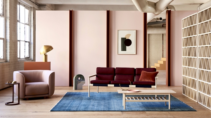 table basse bois, tapis bleu rectangulaire, fauteuil taupe, mur rose pastel