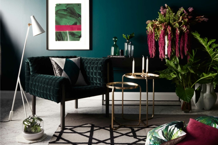 décoration intérieure salon en couleurs tendance, mur bleu canard, tapis blanc aux motifs noirs, plantes vertes, tableau art, petites tables gigognes