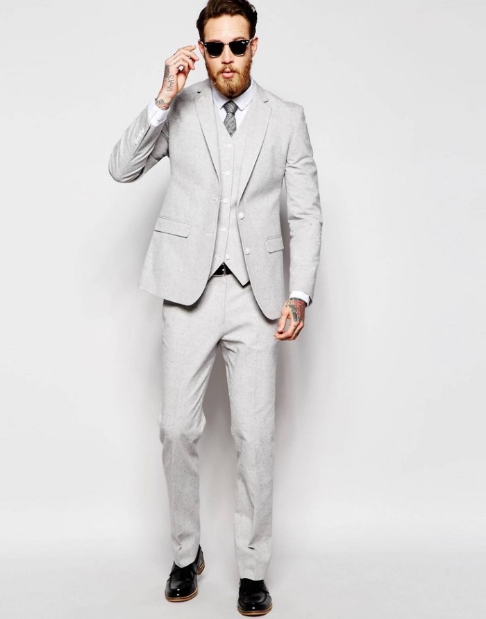 un costume homme pas cher de la marque assos, trois pièces en gris clair rehaussé par une cravate en gris plus foncé et des chaussures cuir verni noir