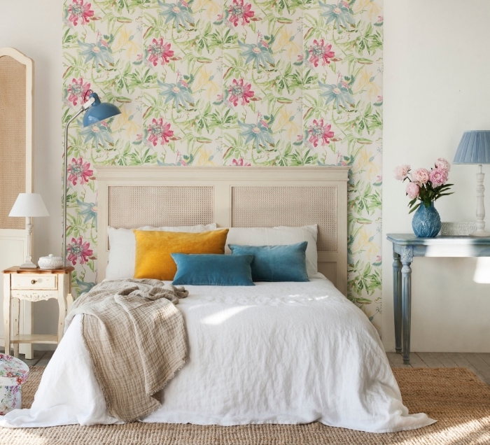 une chambre à coucher beige d'esprit shabby chic avec tete de lit papier peint végétal aux motifs doux et raffinés