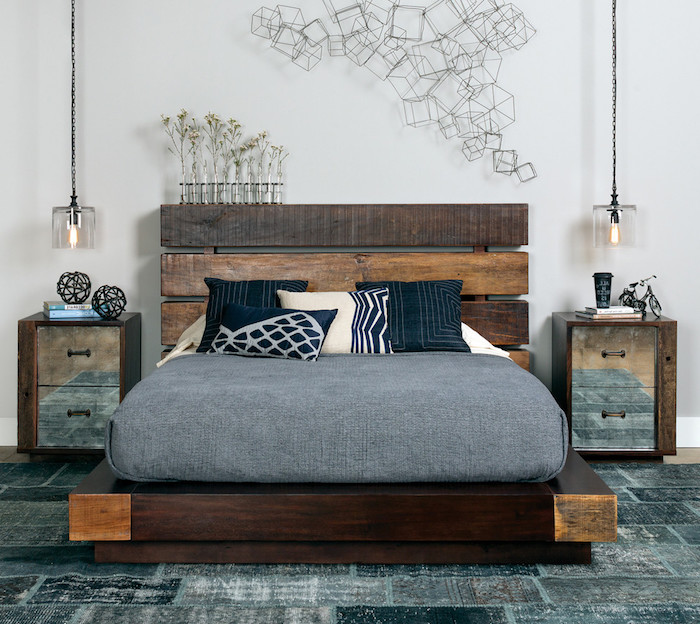 tête de lit en palette de bois, matelas gris sur plate forme bois, tapis gris, table de nuit bois et métal. déco murale composition métallique