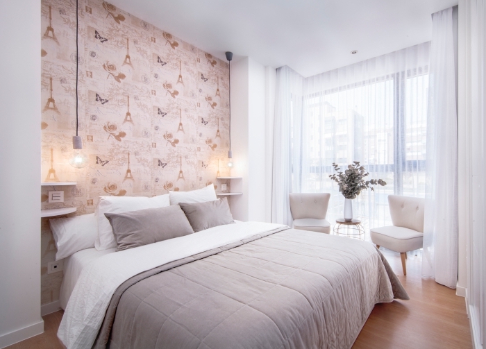 une chambre à coucher au décor doux et épuré avec une niche murale tapissée de papier peint tete de lit à motif tour eiffel