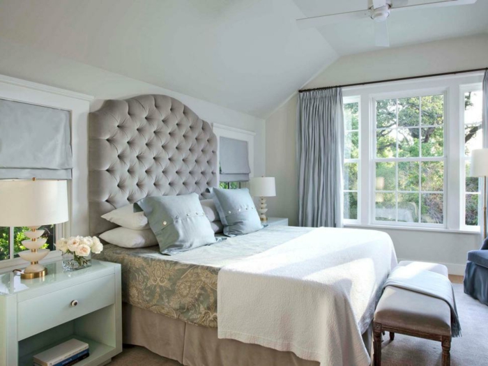 une chambre vintage coquette, tête de lit capitonnée, banquette de lit grise, grande fenêtre blanche