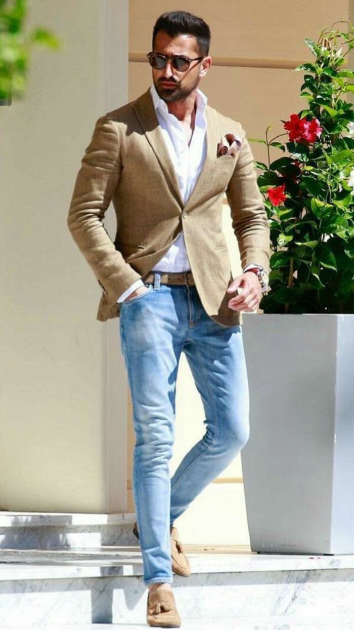 tenue classe homme avec veste en couleur moutarde, denim jean bleu clair blanchi, chemise blanche, mocassins beiges avec des pompons, mouchoir de pochette rouge et blanc en soie