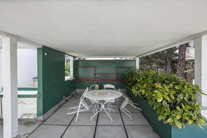 mur végétal intérieur, séparateur d'espace végétal, plantes en vert et jaune, véranda moderne, meubles de jardin en métal blanc, quatre chaises pliantes et une table ronde 