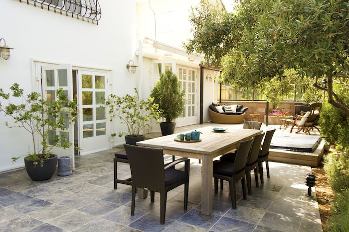 salle à manger extérieure en table et chaises bois, terrasse bois pour aménager un coin détente en chaises bois et canapé rotin, coussins décoratifs