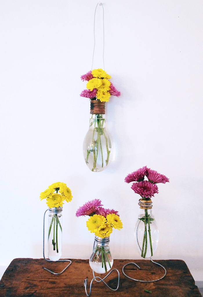 idées loisirs créatifs adultes, ampoule electrique transformée en vase avec de petits bouquets de fleurs à l intérieur, table bois brut