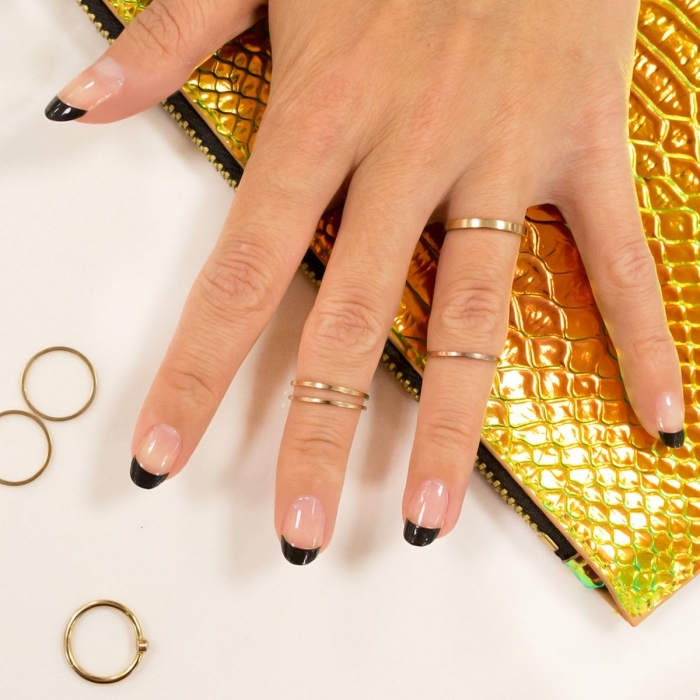 bagues-or-bijoux-femme-ongles-longs-manucure-française-en-noir-modele-ongle-en-gel-technique-nail-art-idée-art-ongles deco ongle en gel à design français avec base transparente et traits noirs, idée manucure facile et élégant en noir