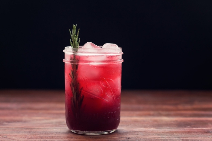 exemple de boisson rafraichissante dans un pot cocktail rempli de jus aux fruits rouges et glaçons garni d'herbe verte