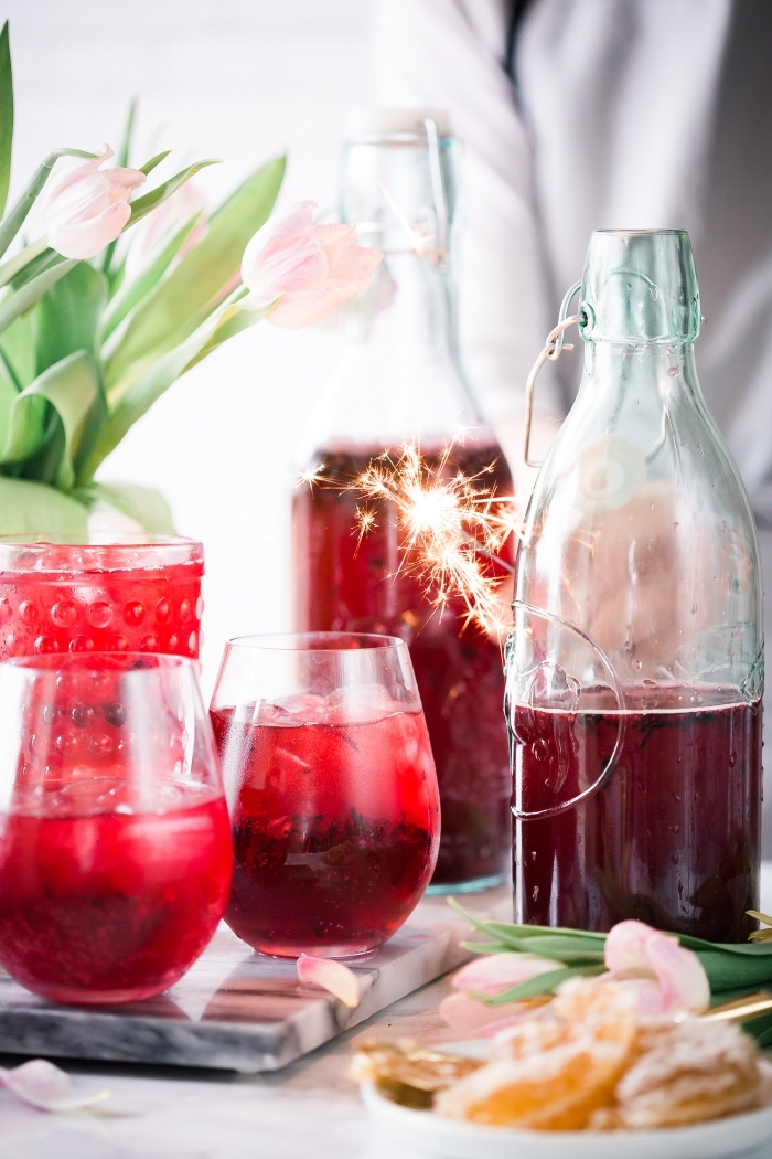 décoration de table avec bouquet de tulipes roses et boisson rafraîchissante aux fruits rouges servie avec glaçons