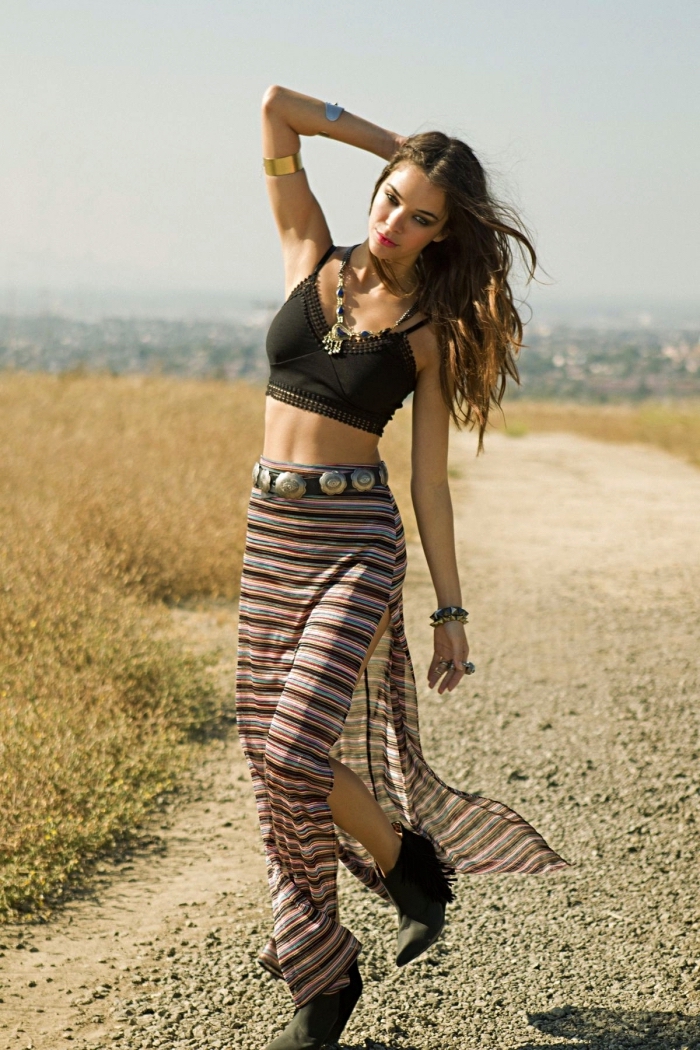 modèle de vetement hippie chic en jupe droite à design rayée en marron et bleu avec ceinture métallique et bottines noires
