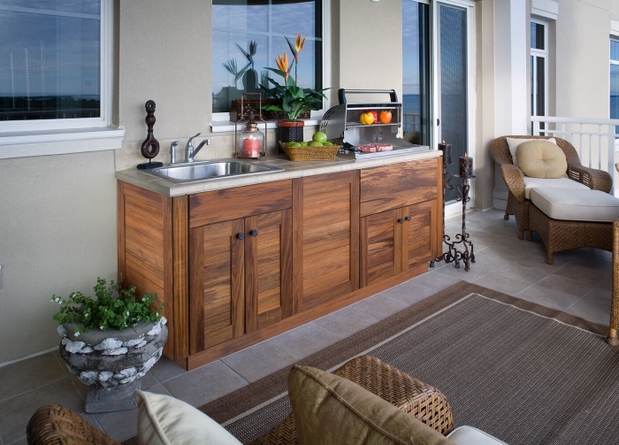 petite cuisine aménagée sur une terrasse avec meubles de bois solide et de rotin, exemple ilot cuisine en bois et inox
