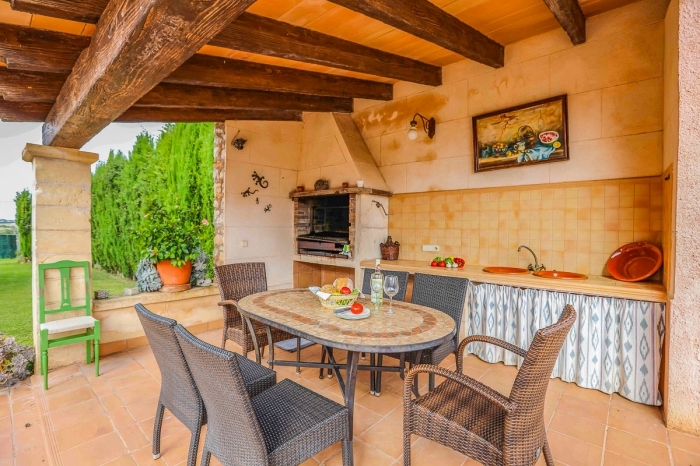 déco de style campagne dans une cuisine de jardin couverte avec toit de poutres bois massif et crédence au carrelage beige