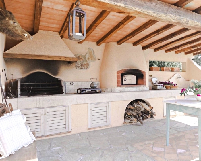 exemple de cuisine d été couverte avec toit de bois massif et sol en larges pierres, déco de cuisine de style rustique et campagnard