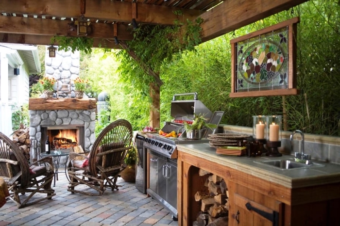 cuisine aménagée de style rustique avec toit de bois et cheminée en pierre, idée choix de barbecue en acier inoxydable