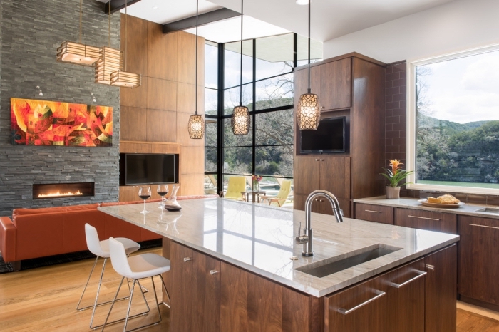 design intérieur moderne dans une cuisine ouverte vers le salon aménagée avec meubles bois foncé et ilot central