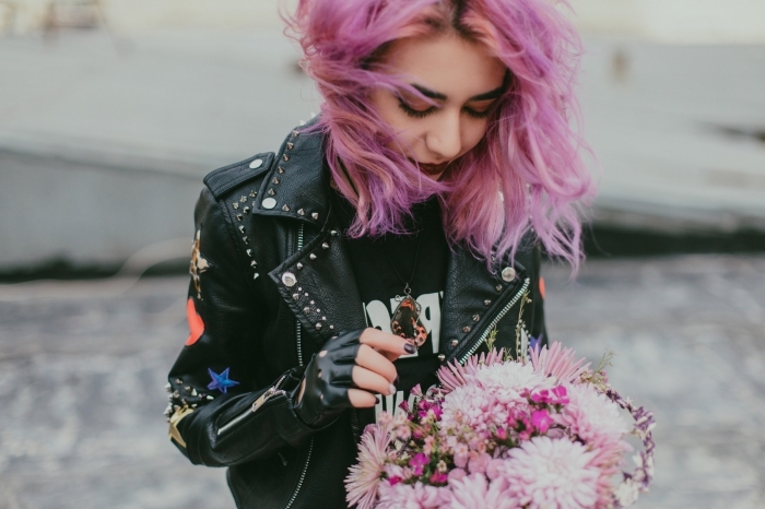 coiffure de style grunge avec racines foncées et coloration de nuance rose pastel et rose foncé, modèle de veste en cuir noir avec décoration étoiles et studs