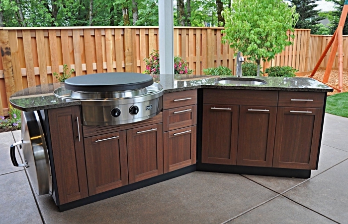 exemple de mini cuisine de jardin avec équipement en acier plan de travail en granite et armoires de bois foncé
