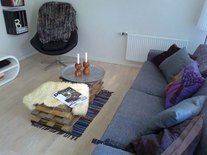 une table basse originale d'esprit scandinave réalisée avec des planches de bois de palette décalées, décorée avec une peau de mouton et un plateau argenté