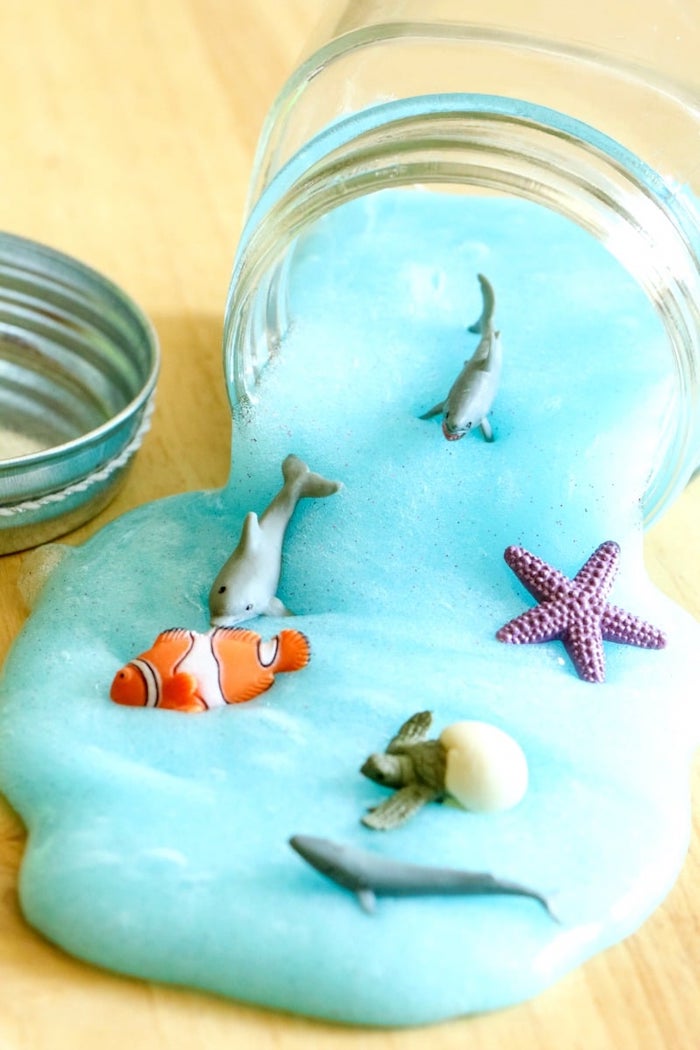 idée pour faire du slime bleu dans un bocal, imitation mer avec des animaux marins, poissons en plastique, activité manuelle 4 ans