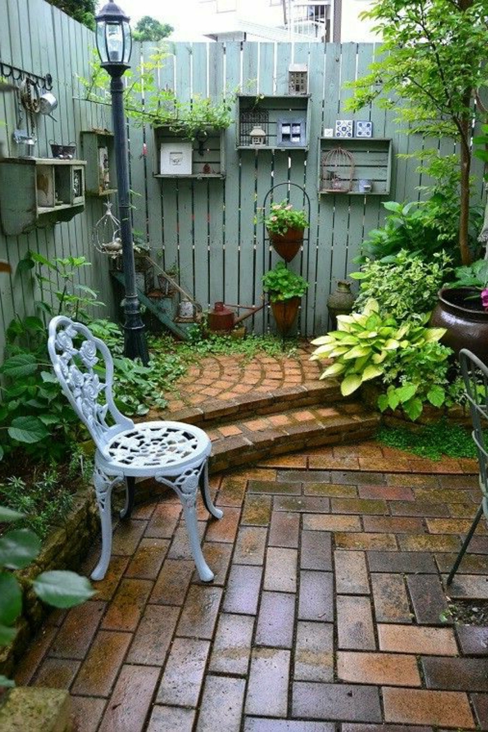 habiller un mur exterieur, aménagement extérieur maison, clôture de bois peint en vert menthe avec des étagères casiers en bois en vert menthe, chaise de jardin style vintage en métal blanc