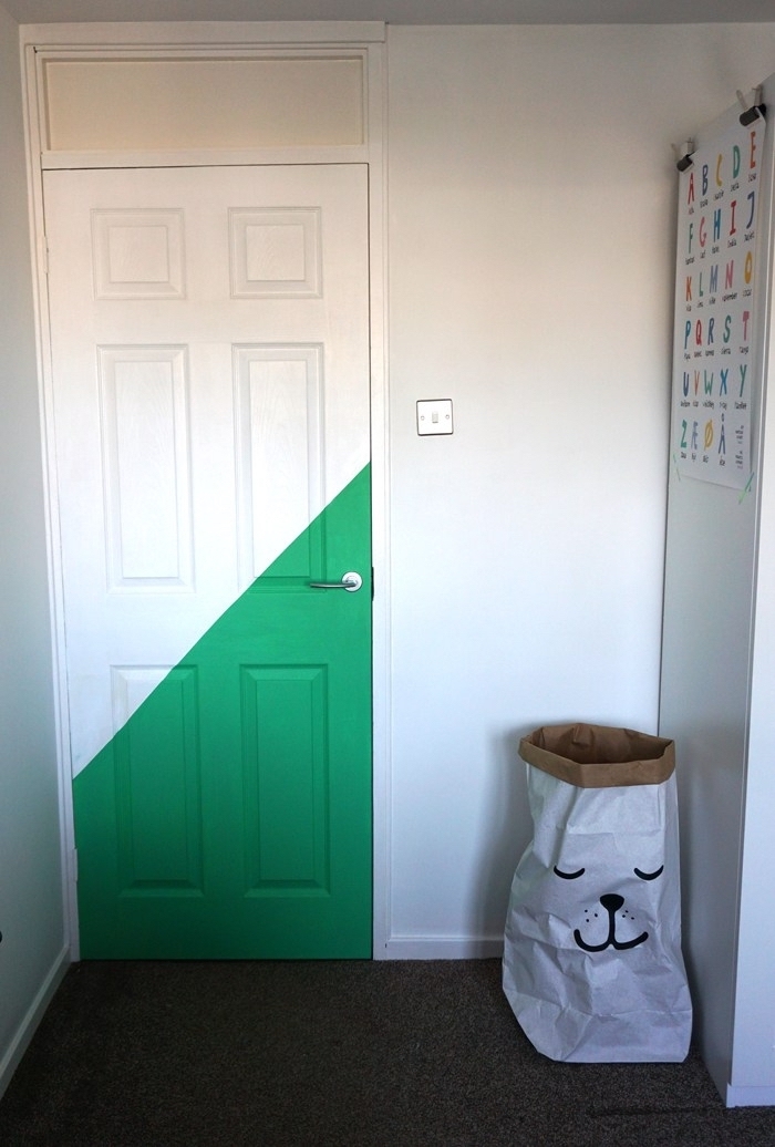 une porte d'intérieur blanche à dessin géométrique en peinture verte qui réveille l'intérieur simplede la chambre d'enfant 