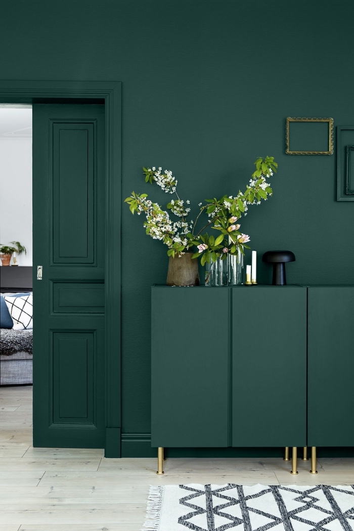 une porte interieure et son encadrement peints de même couleur vert sapin que les murs et la commode, salon design moderne en vert sapin aux accents dorés