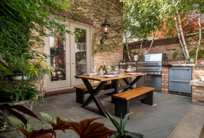déco de style campagnard dans une cuisine d'été ouverte aménagée avec bancs et table à manger de bois et noir