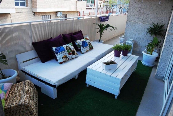 déco stylée du balcon avec clôture en paille et meubles de bois peint en blanc, choix de plantes vertes pour balcon