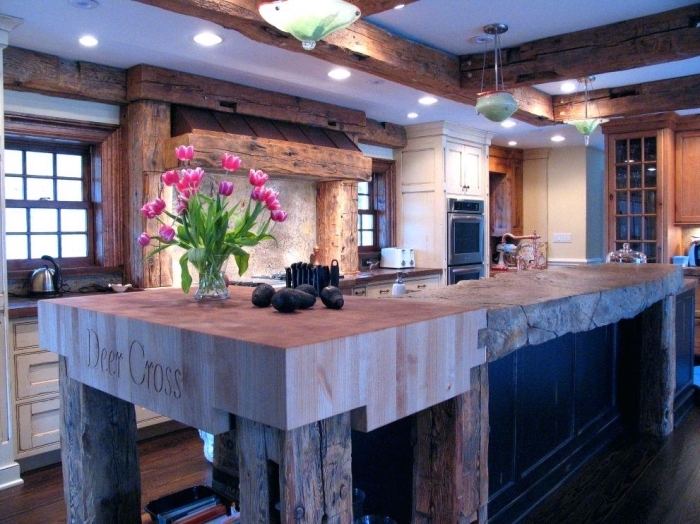intérieur style rustique dans une cuisine aménagée en bois brut, modèle de plafond blanc avec poutres en bois massif et éclairage led