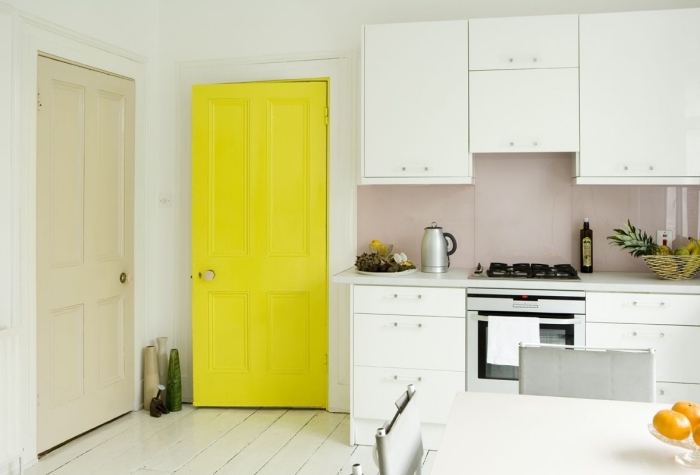 touche de couleur vitaminée dans une cuisine blanche avec une porte interieure repeinte en jaune fluo