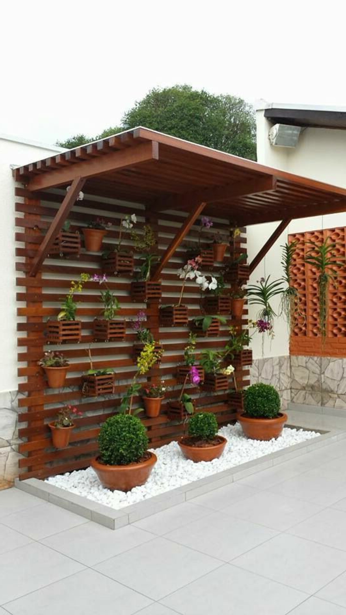 décoration murale extérieure, pergola en bois marron foncé avec des étagères pour les pots de fleurs, toit rectangulaire en bois pour préserver les plantes 